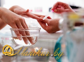 Woman soaks her fingernails in water while getting a manicure.